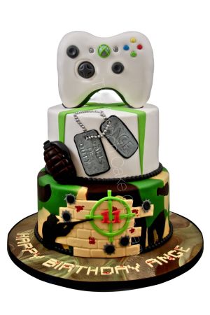 Gâteau d'anniversaire Xbox Call of Duty à deux étages avec motif camouflage militaire, plaques d'identification, grenade et manette 3D en sucre, créé par The French Cake Company.