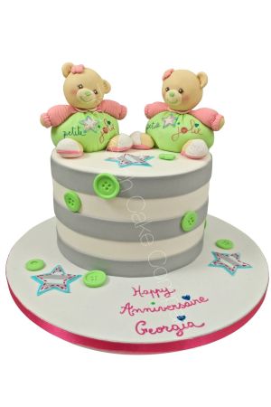Gâteau d'anniversaire personnalisé à rayures grises et blanches orné de boutons verts en sucre, d'étoiles et de deux oursons en peluche style Kaloo sculptés en 3D, créé par The French Cake Company.