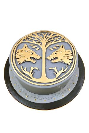 Gâteau d'anniversaire rond sur le thème du jeu vidéo Destiny recouvert d'un glaçage gris, orné de l'emblème doré de la Bannière de Fer avec ses deux loups et l'arbre de vie, créé par The French Cake Company.