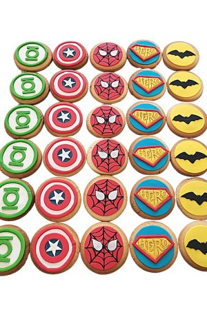 A collection of round cookies decorated with colorful fondant superhero logos: Green Lantern, Captain America, Spider-Man, Superman, and Batman.