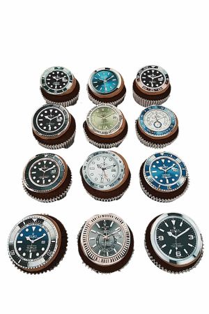 Un assortiment de cupcakes décorés de disques comestibles illustrant différents cadrans de montres de luxe Rolex.