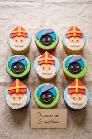 Box of custom handmade Saint Nicholas cupcakes for Sinterklaas, decorated with fondant toppers of Saint Nicholas and his helper.