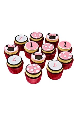 Un assortiment de cupcakes décorés sur le thème de Minnie Mouse avec des pois roses, des silhouettes de tête de souris et le chiffre un.