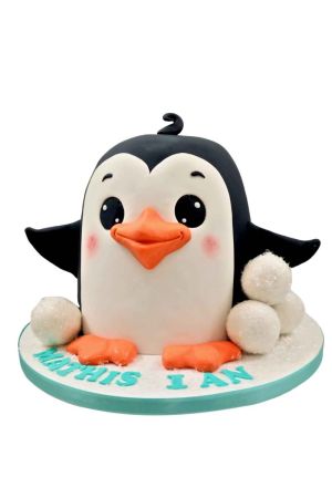 Un gâteau d'anniversaire sculpté en 3D en forme de pingouin mignon noir et blanc avec des joues roses, un bec orange et de grosses boules de neige blanches en sucre.