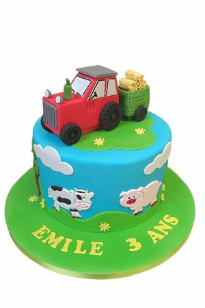 A tractor and trailer on top of a farm themed cake for children's birthdays