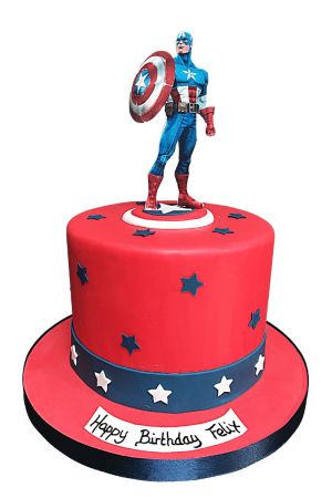 Red fondant birthday cake with blue and white sugar stars, blue ribbon band, and a Captain America superhero figurine holding a shield on top by The French Cake Company