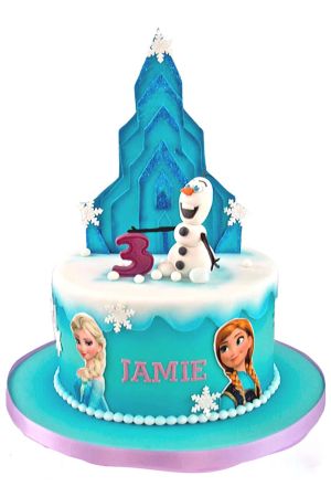 Custom round turquoise Frozen birthday cake with snowy white icing drip, snowflakes, edible pictures of Elsa and Anna, a 3D Olaf snowman topper, purple number 3, and a glittery blue ice castle backdrop, created by The French Cake Company.