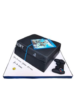 Un gâteau d'anniversaire sculpté en 3D en forme de console PS4 noire avec une manette de jeu réaliste et une image comestible du jeu Fortnite.