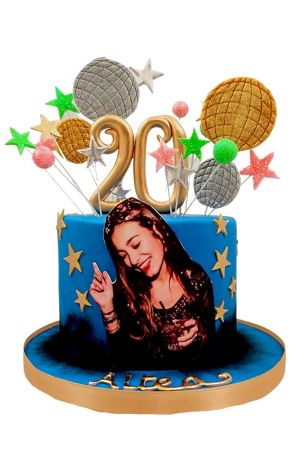 Un gâteau d'anniversaire en pâte à sucre bleue avec une photo personnalisée, un chiffre 20 doré et des décorations de boules disco.