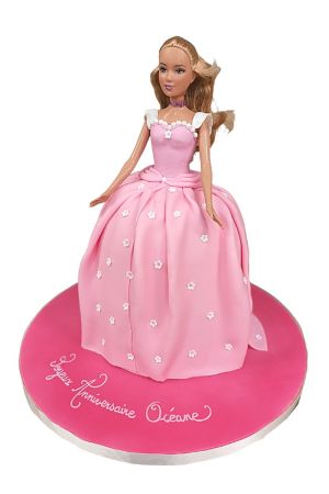 Gâteau d'anniversaire poupée Barbie blonde habillée d'une grande robe rose tendre constellée de petites fleurs blanches sur plateau fuchsia réalisé par The French Cake Company