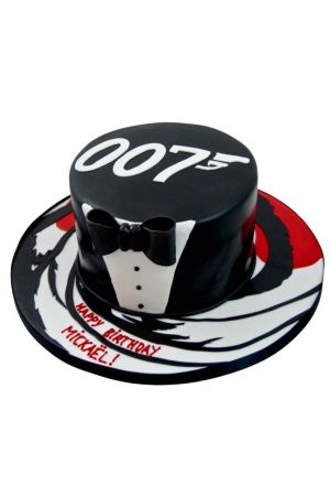 Gâteau d'anniversaire sur mesure James Bond 007 représentant un smoking noir élégant avec nœud papillon sur un socle motif canon de revolver, créé par The French Cake Company.