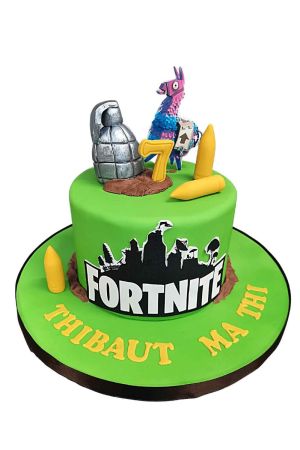 Exclusieve groene Fortnite verjaardagstaart gedecoreerd met het bekende logo, gele munitie, een grote zilveren granaat en een 3D buitllama taarttopper, van The French Cake Company.