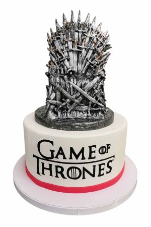 Gâteau d'anniversaire sur mesure Game of Thrones sur fond blanc, orné du logo officiel de la série et surmonté d'un Trône de Fer détaillé, créé par The French Cake Company.