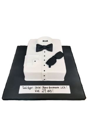 Gâteau d'anniversaire rectangulaire en forme de chemise blanche pliée avec nœud papillon noir, boutons en sucre et lunettes de soleil, créé par The French Cake Company.