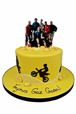 Gâteau d'anniversaire personnalisé motocross jaune avec silhouettes de motards noires, décors en sucre et impression photo au sommet, créé par The French Cake Company.