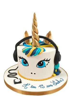 Gâteau d'anniversaire licorne tendance pour ado avec corne dorée, crinière bleue et jaune, yeux bleus et casque audio en sucre, créé par The French Cake Company.