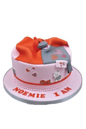 Gâteau du 1er anniversaire rose poudré avec doudou couverture orange et gris modelé en pâte à sucre et tête de canard Babette de Noukie's réalisé par The French Cake Company