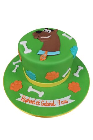 Vibrant green round birthday cake decorated with a flat Scooby-Doo face topper, white sugar bones, and colourful paw prints