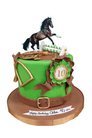 Gâteau d'anniversaire vert équitation décoré d'un cheval noir sautant un obstacle, fer à cheval doré, étriers, ceinture en cuir et flot de récompense réalisé par The French Cake Company