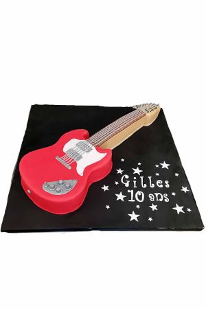 Gâteau d'anniversaire sculpté 3D guitare électrique rouge avec cordes argentées et potentiomètres conçu par The French Cake Company