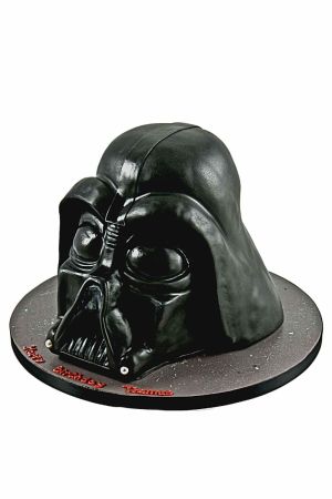 Une sculpture comestible détaillée du casque de Dark Vador, réalisée à partir de gâteau et de pâte à sucre, capturant son masque noir et argent emblématique et son expression menaçante.