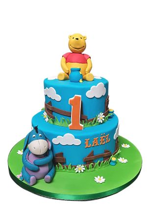 Winnie the Pooh on a tiered birthday cake with decorations