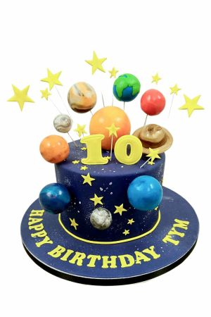 Deep blue galaxy birthday cake adorned with 3D fondant planets on wires, yellow star toppers, and a galaxy display base