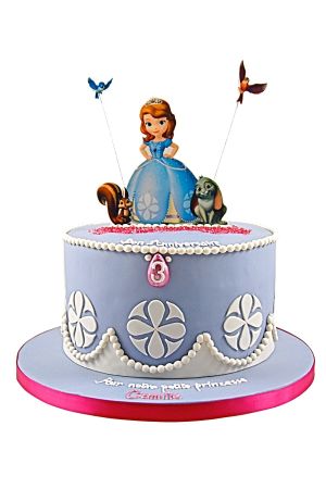 Un gâteau d'anniversaire bleu ciel décoré de perles blanches et de figurines de la Princesse Sofia avec ses amis les animaux.