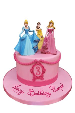 A round pink fondant birthday cake decorated with sugar pearl swags and a dark pink frame featuring the number three, topped with Disney figurines of Cinderella in her blue gown, Belle in yellow, and Aurora in pink.