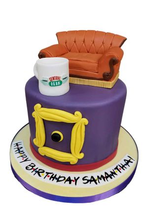 Exclusieve paarse Friends verjaardagstaart gedecoreerd met de gele doorkijklijst, een 3D oranje Central Perk bank en een koffiemok van suiker, van The French Cake Company.