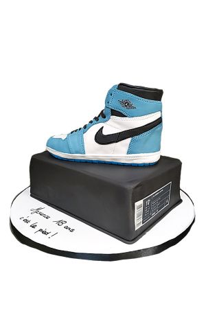 Un gâteau au design complexe, moulé et décoré pour ressembler à une basket Air Nike bleue et blanche.