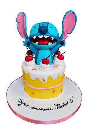 A yellow and white birthday cake with fondant cherries, featuring a 3D Stitch figurine with his arms raised, popping out of the center.