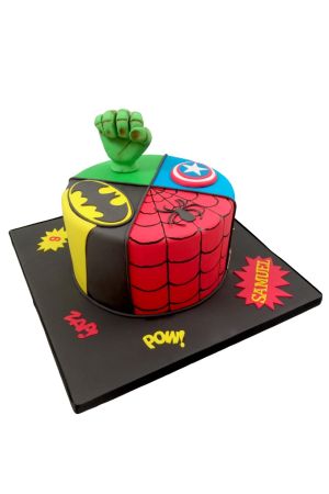Un gâteau d'anniversaire rond divisé en quatre sections (Hulk, Batman, Spiderman, Captain America) avec un poing de Hulk vert au sommet.