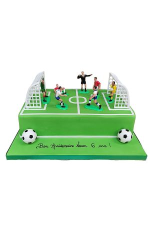 Een verjaardagstaart versierd als een voetbalveld, compleet met groene glazuur, witte lijnen en miniatuurdoelen.
