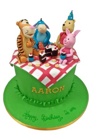 Winnie en haar vrienden zitten op een geruit kleed bovenop een taart en houden een picknick.