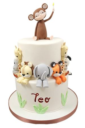 Gâteau de baptême à deux étages blanc décoré d'animaux de la jungle en 3D : éléphant, lion, tigre, girafe et un singe au sommet.