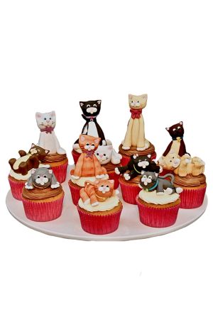 A collection of cupcakes decorated with various handcrafted edible sugar cats and kittens in different colors and playful positions.