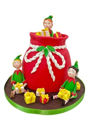 Des lutins et un gâteau dans un panier de cadeaux de Noël