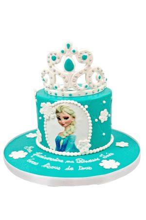 Gâteau d'anniversaire personnalisé bleu turquoise La Reine des Neiges orné de flocons blancs, d'un portrait d'Elsa, d'effets matelassés et d'une superbe couronne, créé par The French Cake Company.