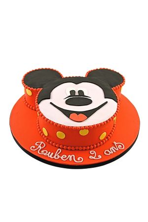Gâteau d'anniversaire personnalisé en forme de tête de Mickey Mouse avec contour rouge à pois jaunes et bordure perlée, créé par The French Cake Company.