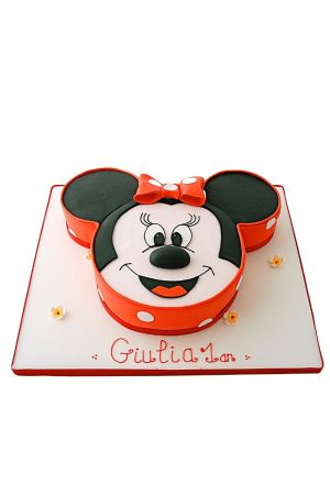 luxury custom birthday cake sculpted into the 3D shape of Minnie Mouse's head, featuring her red polka-dot bow and a personalized name on the white cake board.