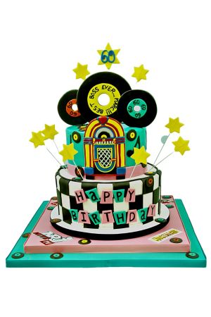 Une pièce montée d’anniversaire à deux étages en pâte à sucre avec un motif de damier noir et blanc et un étage turquoise orné d'un jukebox rétro en 3D, de disques vinyles noirs et d'étoiles jaunes jaillissantes.