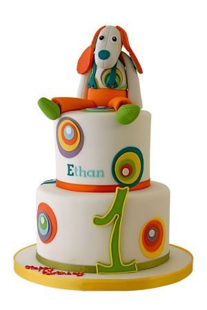 Un gâteau d'anniversaire Ebulobo fantaisiste décoré de couleurs vives, mettant en scène des personnages ludiques et des détails fantaisistes, sur un arrière-plan flou.
