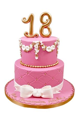 Une luxueuse pièce montée rose pour un 18ème anniversaire, décorée de chiffres dorés, d'un motif matelassé, de guirlandes de fleurs et d'un nœud en sucre blanc.