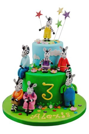 Gâteau d'anniversaire à étages représentant Zou le petit zèbre et ses amis, avec l'âge et le nom.