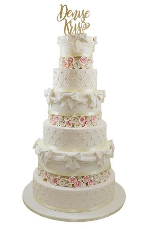 Bruidstaart met bloemen en boog