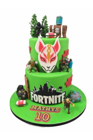Exclusieve dubbellagige groene deluxe Fortnite verjaardagstaart gedecoreerd met het iconische Drift masker, een schatkist, schilddrank, Boogie Bomb, medkit en 3D avatars, van The French Cake Company.